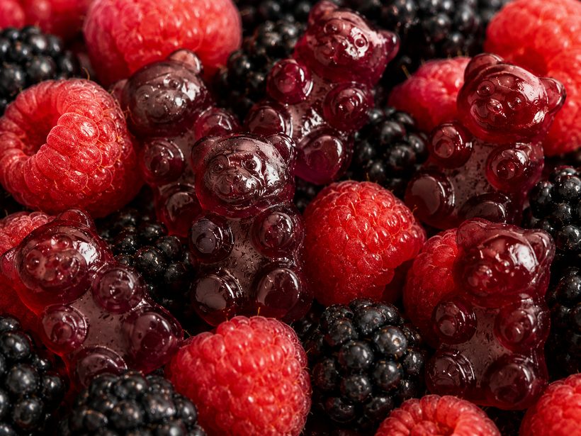 Glossy wild berry moonbear gummy bears among fresh berries